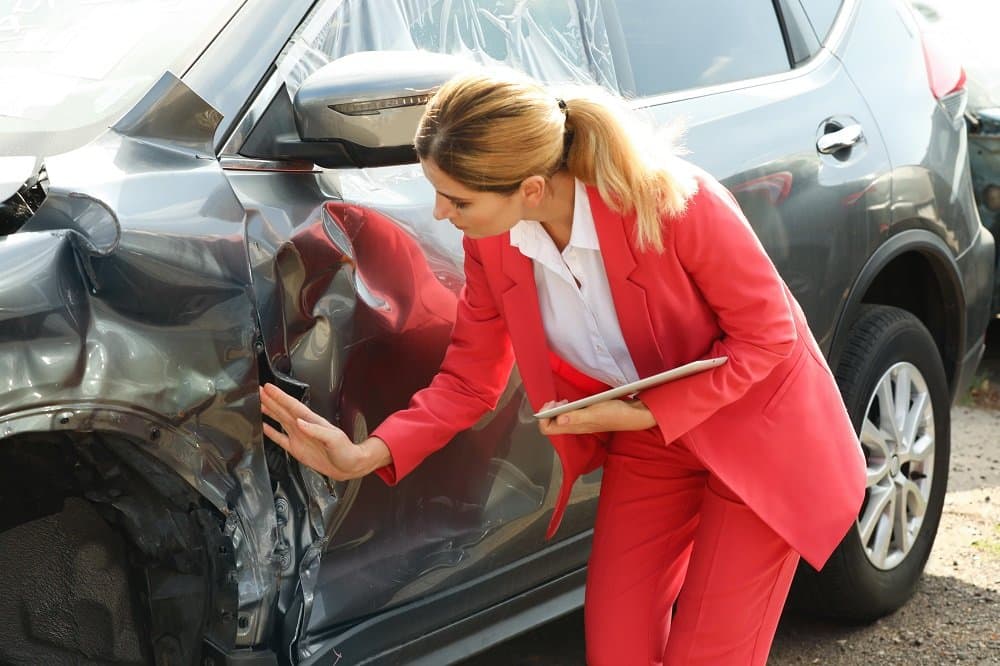 Insurance agent checking carefully the damages.