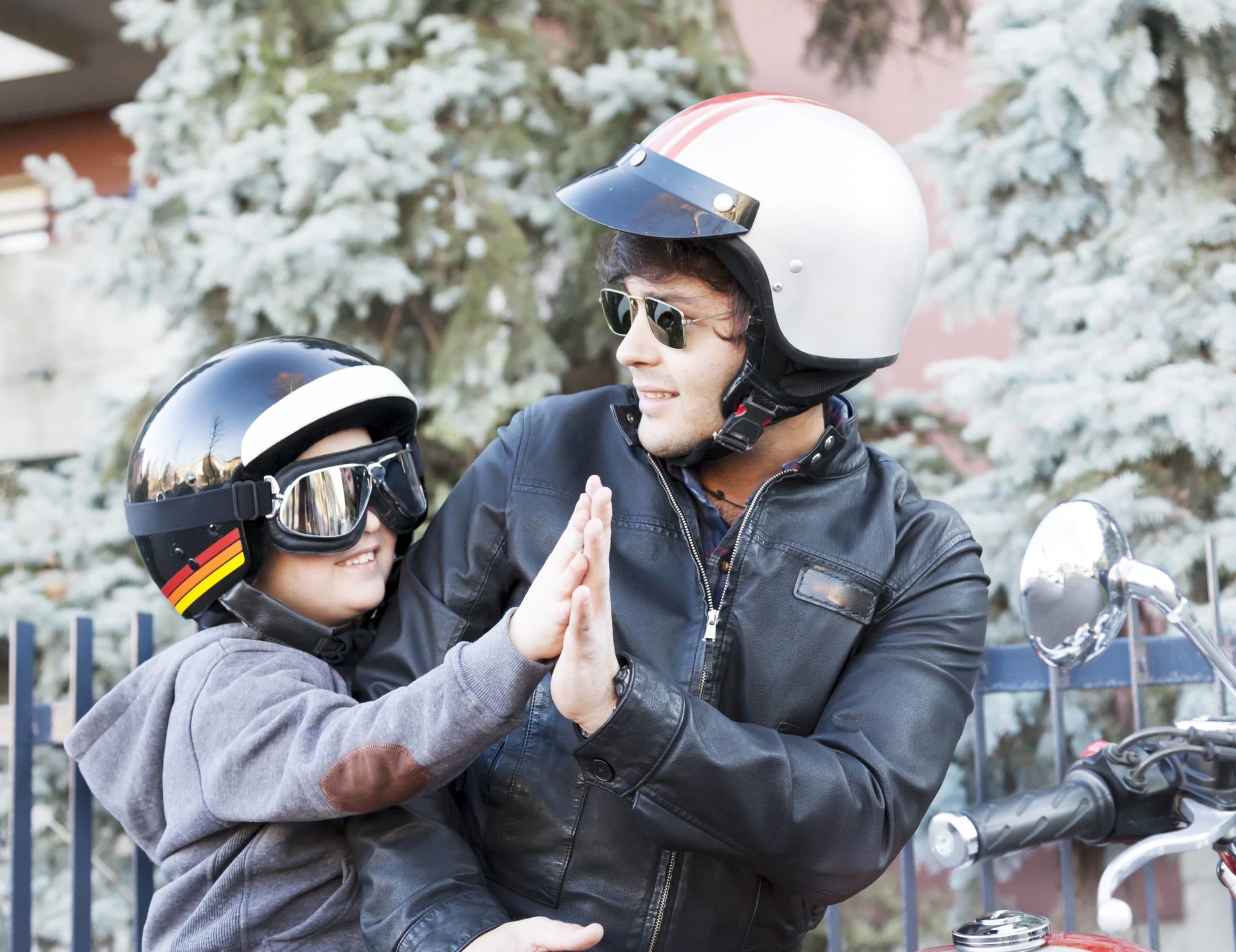 Kid on motorcycle wearing helmet and goggles for safety.