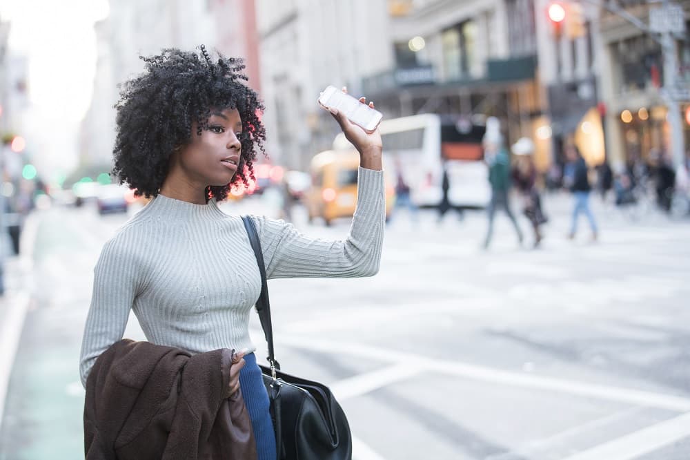 Woman passenger waving at the driver of the uber cab.