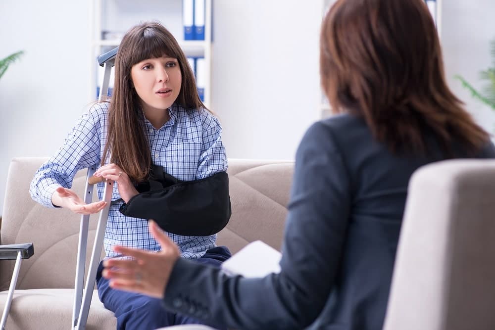 Injured woman asking lawyer why she can't see her doctor for check-up.