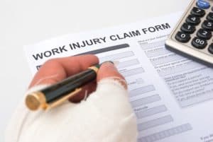 Injured worker filling out Colorado work injury claim paperwork.