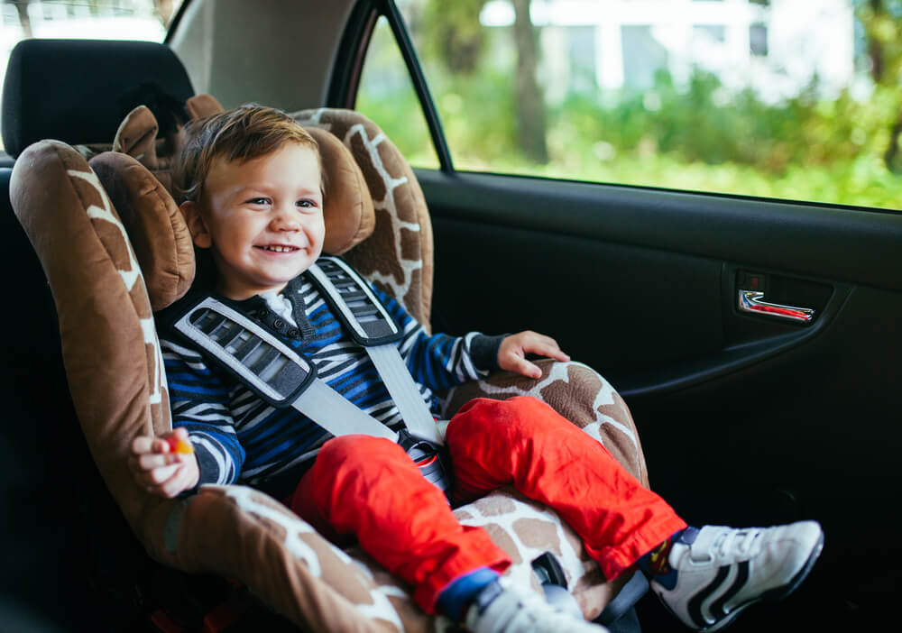 Boy toddler sitting in car seat.