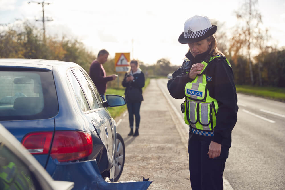 Police officer reporting car crash to nearest station.