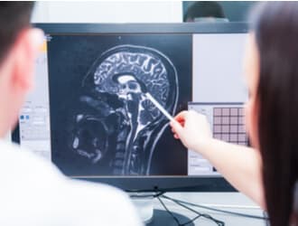 A doctor and a Denver brain injury lawyer look at a scan of a TBI.
