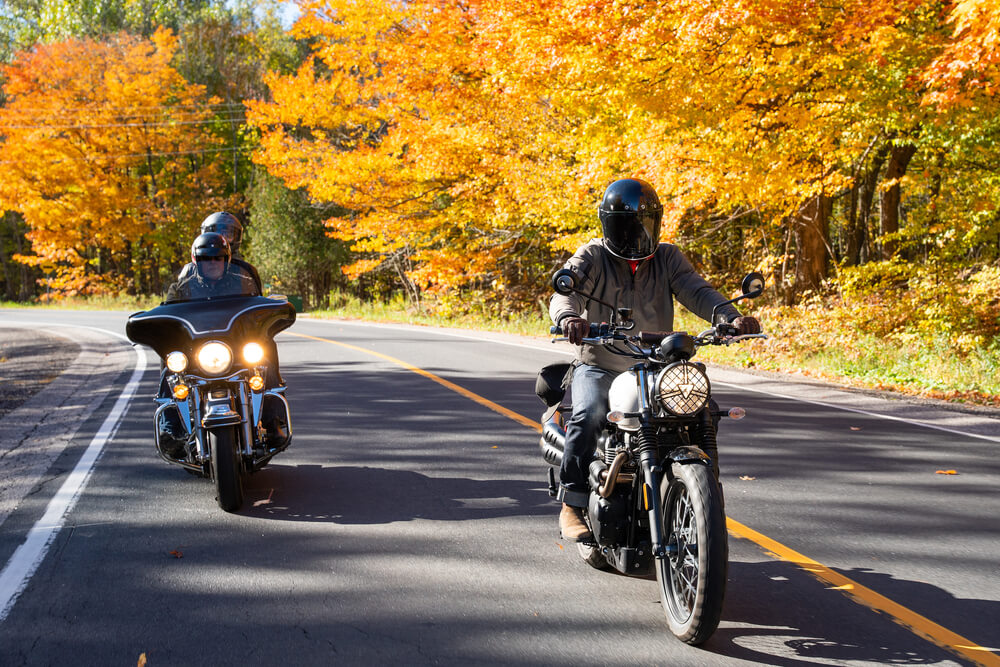 Group of friends riding motorcycles in fall season.