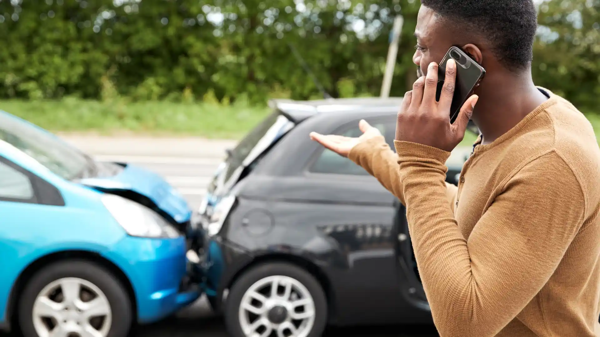 Driver on phone after a car accident between two vehicles.