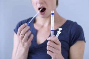 Woman using a DNA test swab inside her mouth