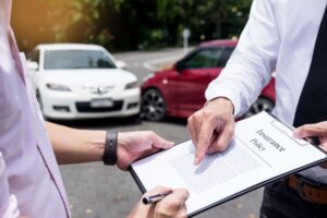 Man pointing at insurance form after a car accident.