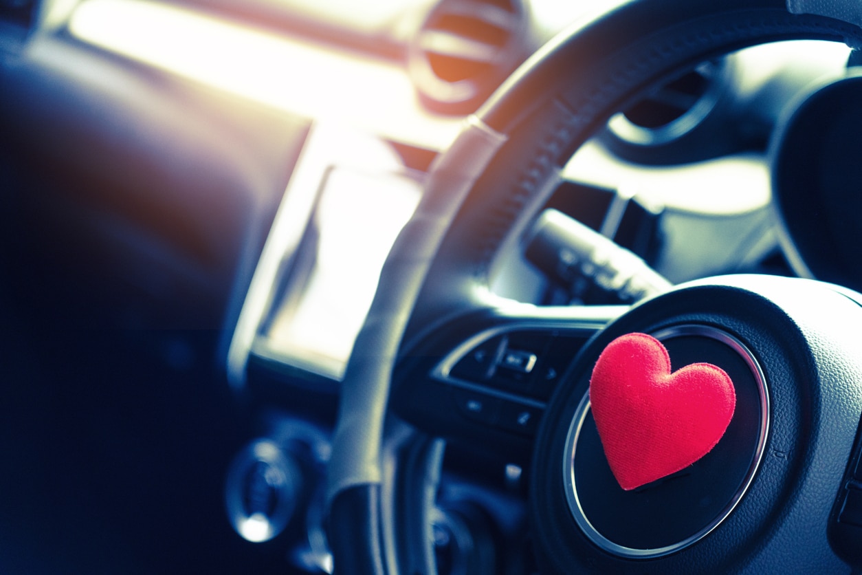 Steering wheel with heart red object.